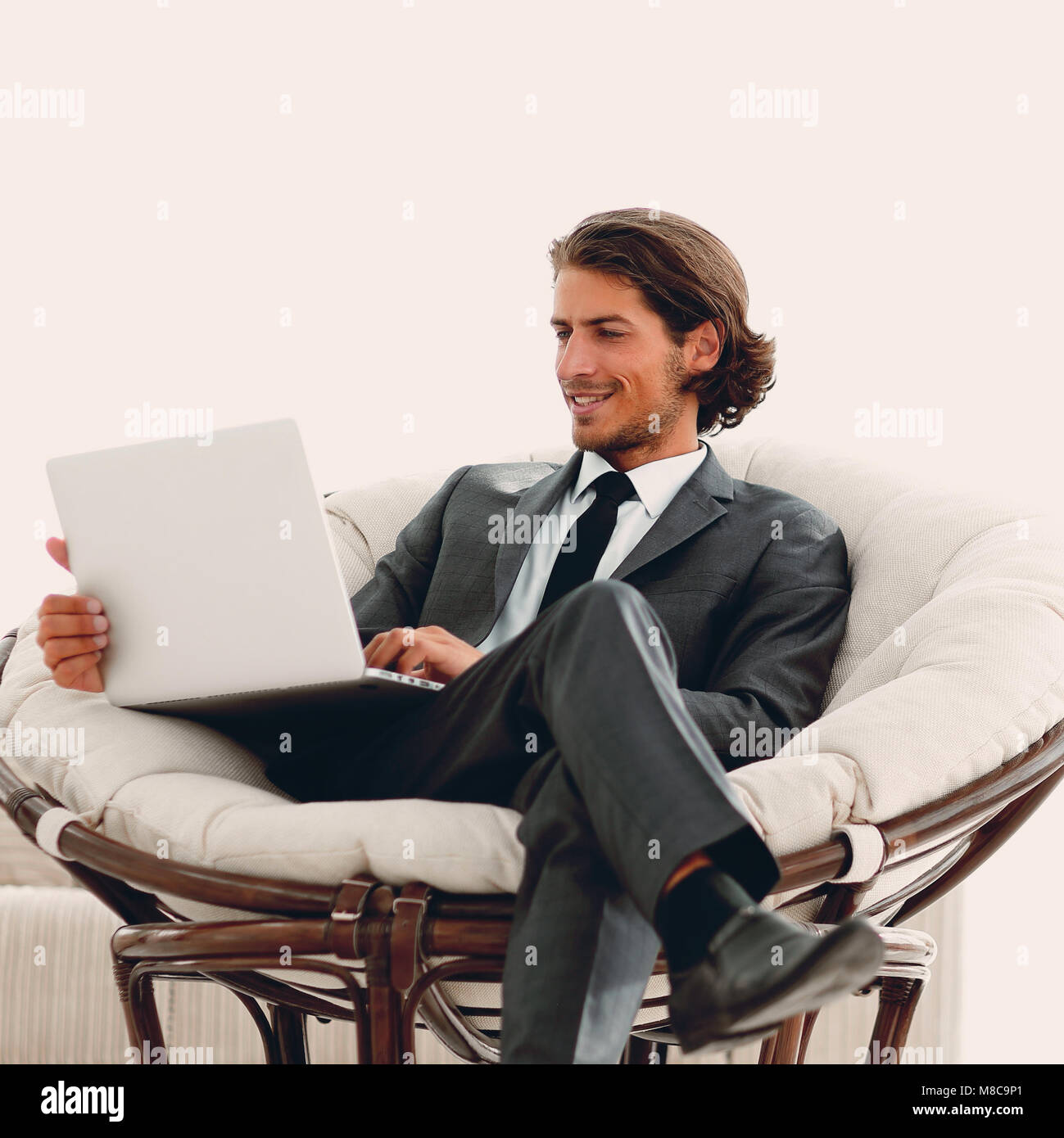 modern businessman with a laptop sitting in a stylish comfortable chair ...