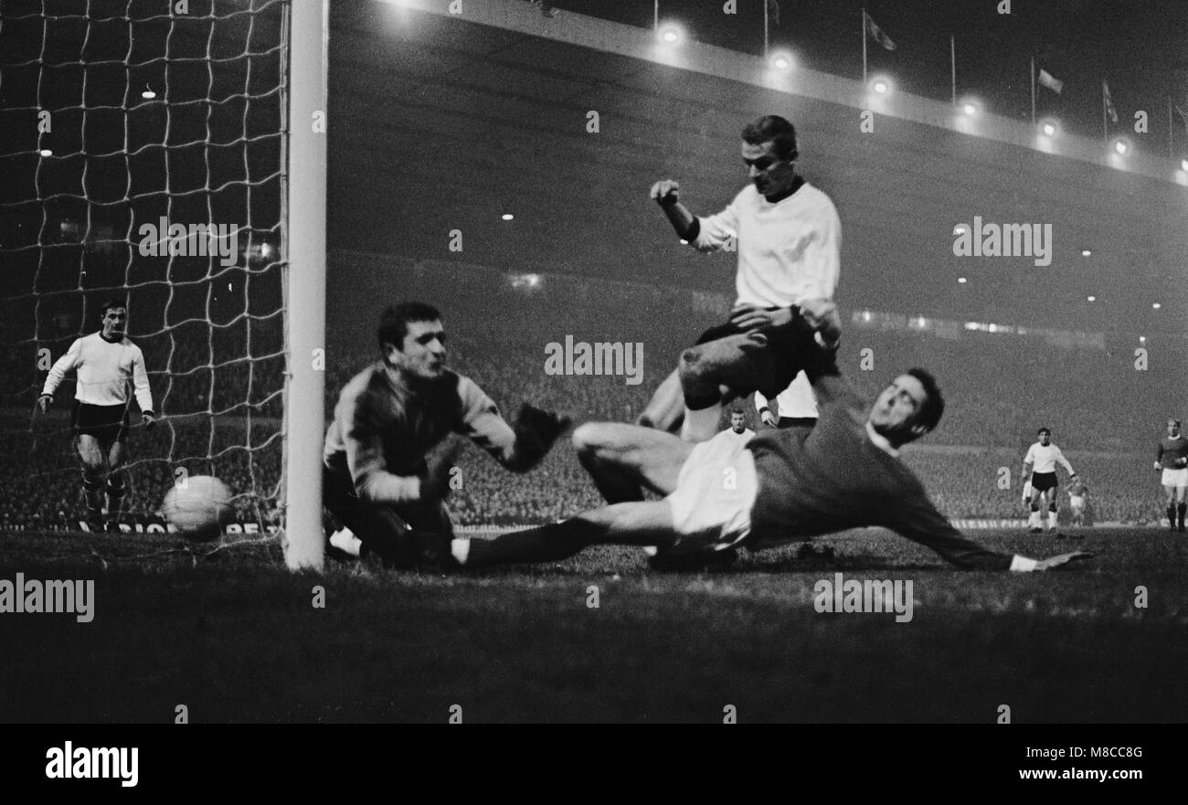 Manchester United winger, Johnny Aston slides in and pushes the ball into the net under the dive of Sarajevo goalkeeper, Muftic, for Manchester United's first goal in the First Round, Second leg European Cup match at Old Trafford. Manchester United won on aggregate 2-1, with the goals scored by Johnny Aston and George Best. Salih Delalic scored for Sarajevo. Stock Photo