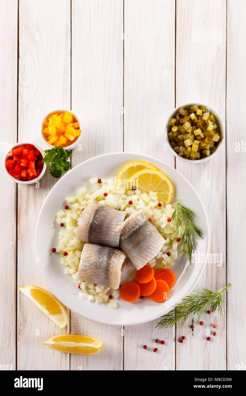 Marinated herring fillets on wooden table Stock Photo