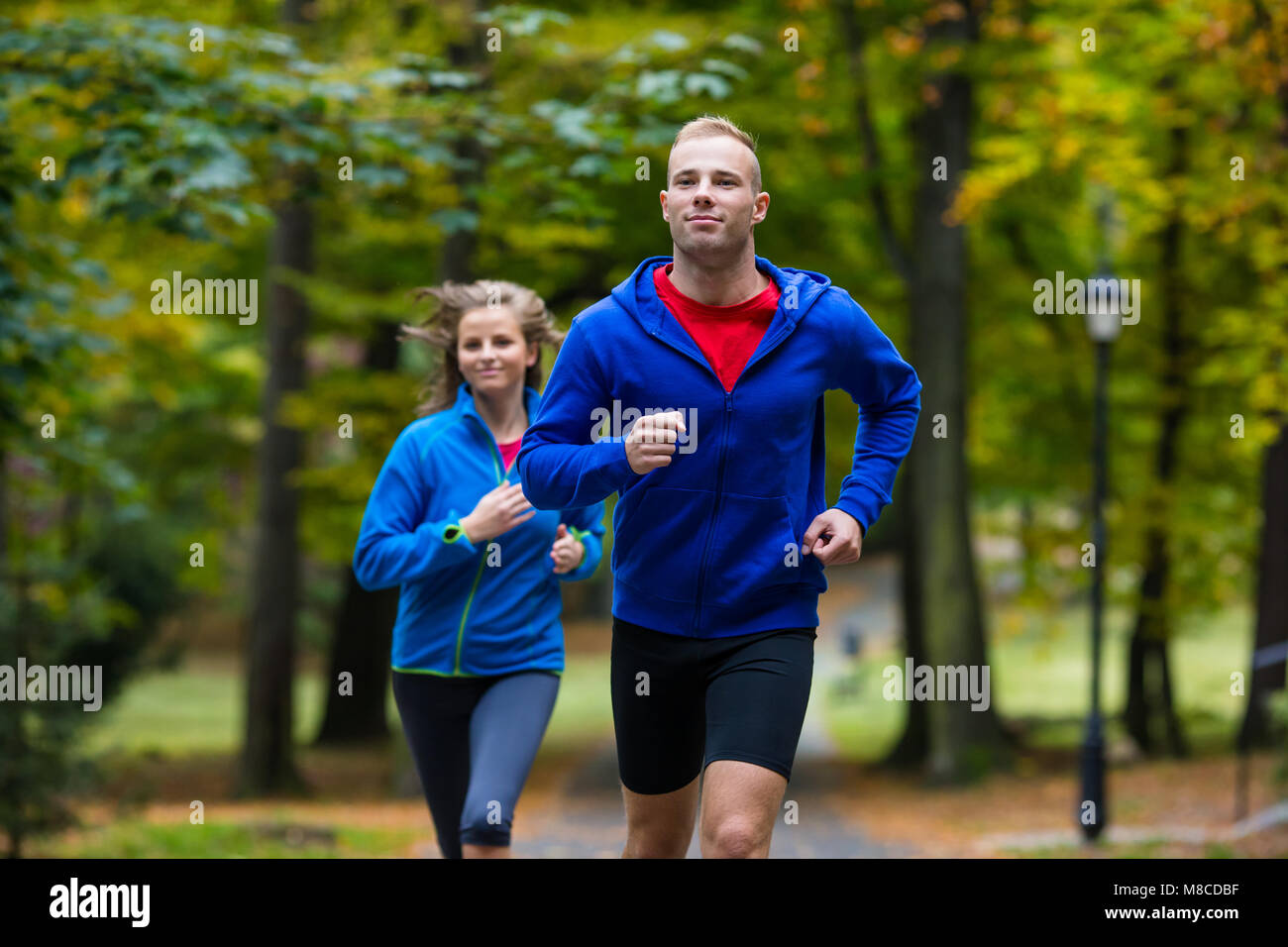 Healthy lifestyle - woman and man running in park Stock Photo