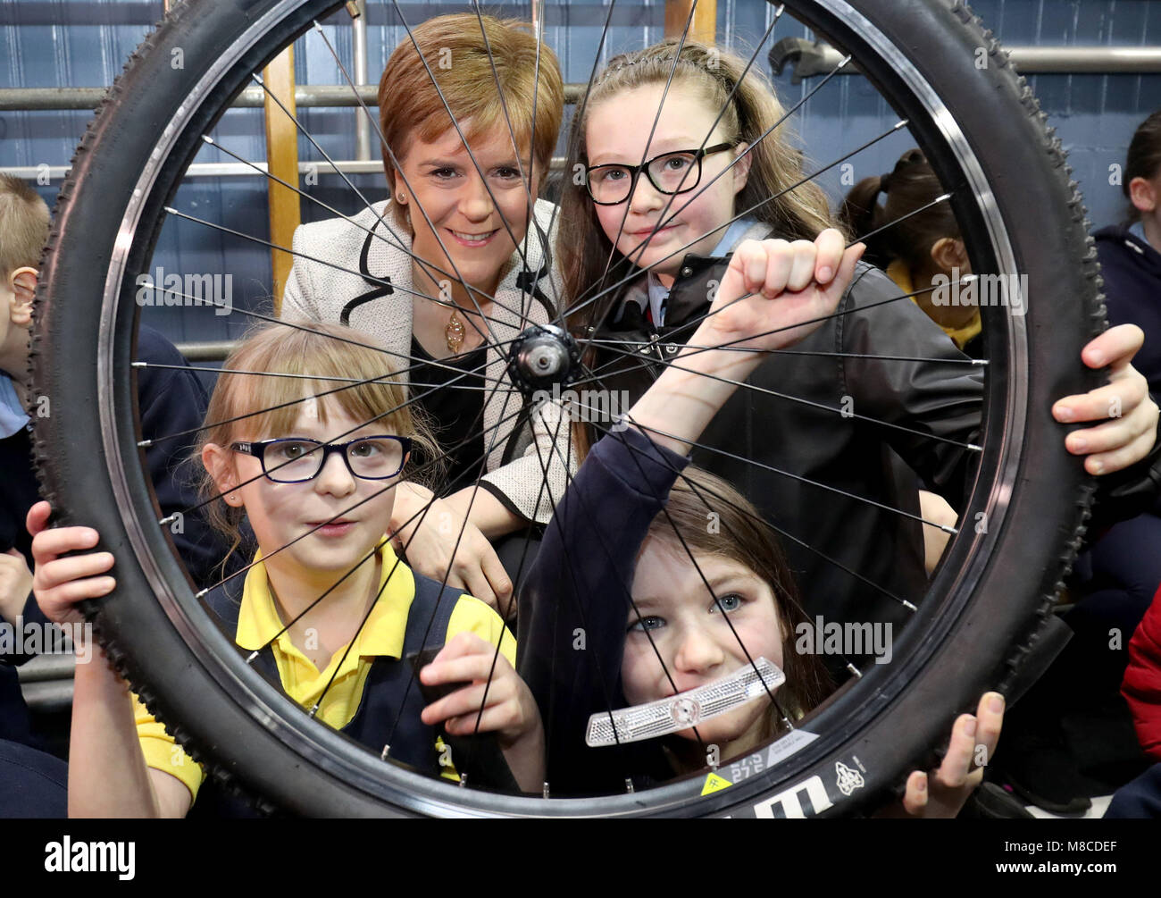 First Minister Nicola Sturgeon takes part in a bikeability repair workshop with pupils Kacey McGairy, 11 (right), Cloe Kerr, 8 (bottom right) and Ailsa Beaton, 8 (bottom left), at Wellshot Primary School in Glasgow as she launches the latest round of Climate Challenge Funding which includes the 1,000th recipient, the Bike for Good project at the school. Stock Photo