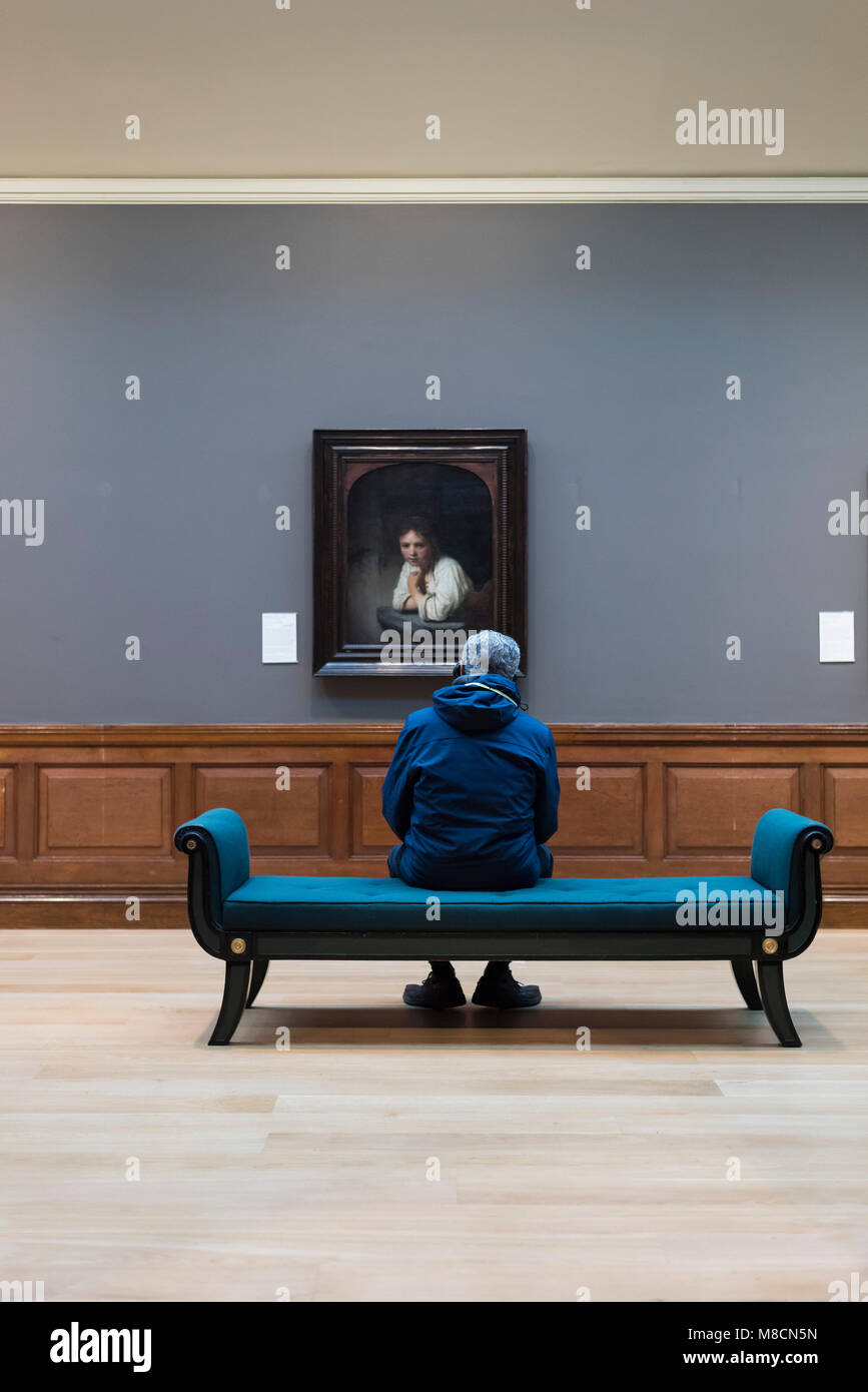 London. England. UK. Dulwich Picture Gallery, visitor looking at Rembrandts' 'A Girl at a Window', 1645. Stock Photo