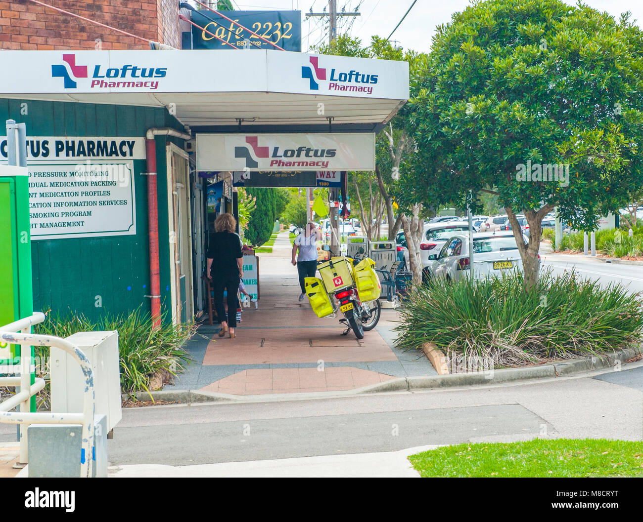 Suburban Loftus. View of local shops with mailman and people walking. LOFTUS. NSW. AUSTRALIA Stock Photo