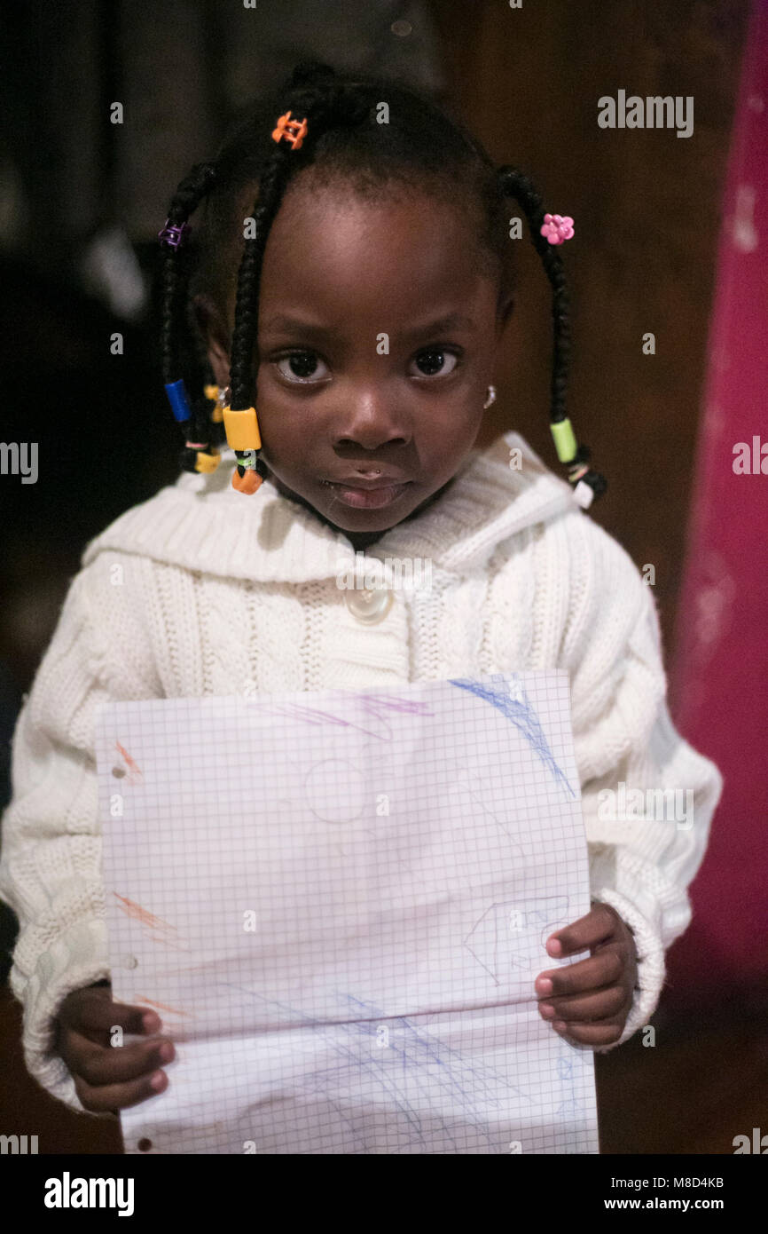 African girl shows his drawing at a dinner organised at the Arci Camalli from S.P.R.A.R. of Imperia Stock Photo