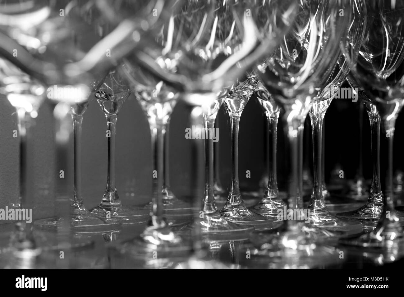 Detail in black and white of many goblets grouped in row ready to be used Stock Photo