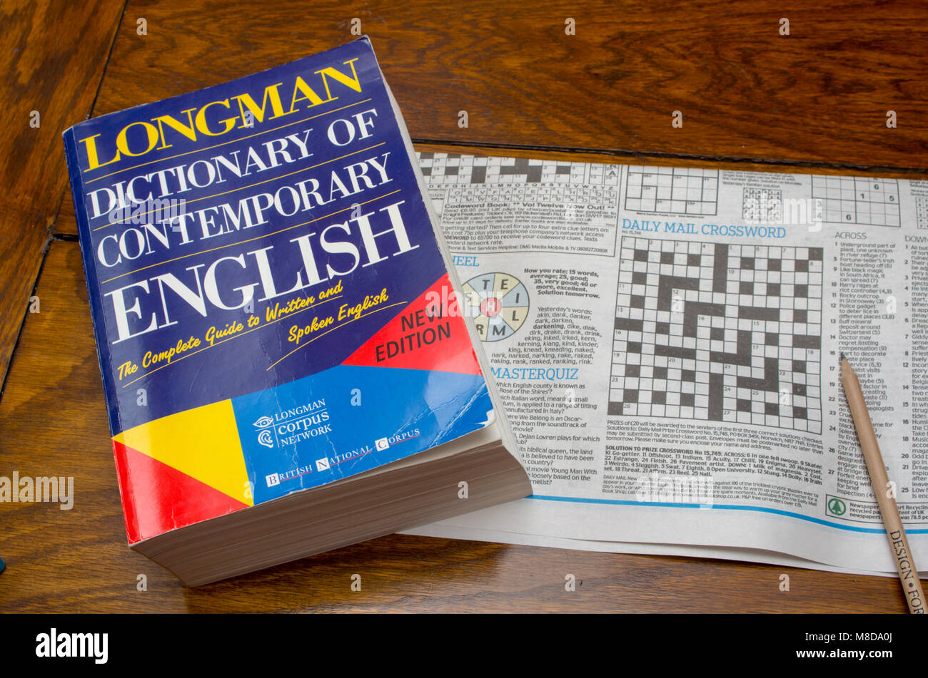 Longman Dictionary of Contemporary English with newspaper crossword puzzle and pencil Stock Photo