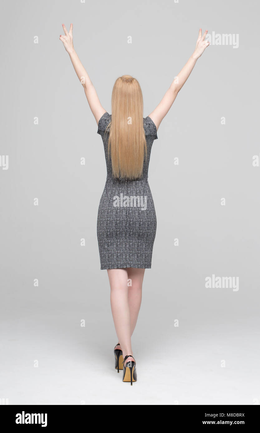 Happy businesswoman hands up on gray background, arms raised Stock Photo