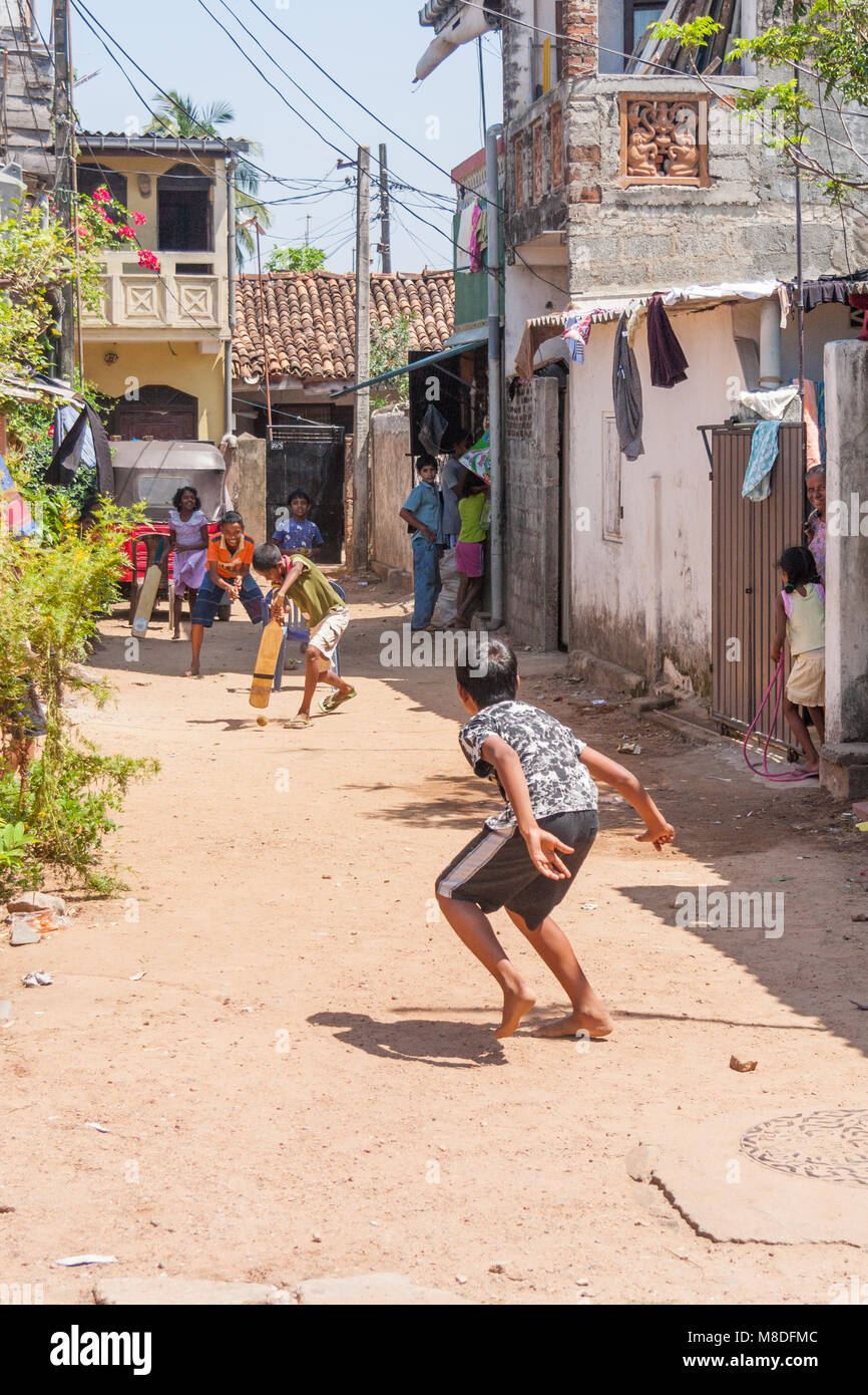 Young Sri Lankan boys playing cricket in the street, Colombo, Sri Lanka Stock Photo