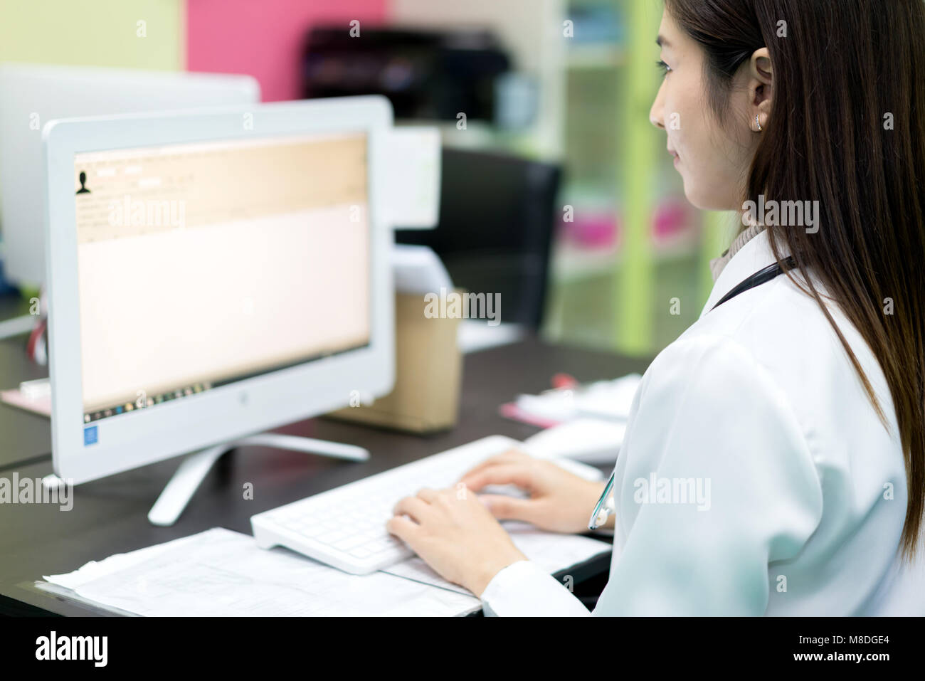 Asian woman doctor searching patient information from medical record system by using computer in hospital. Stock Photo