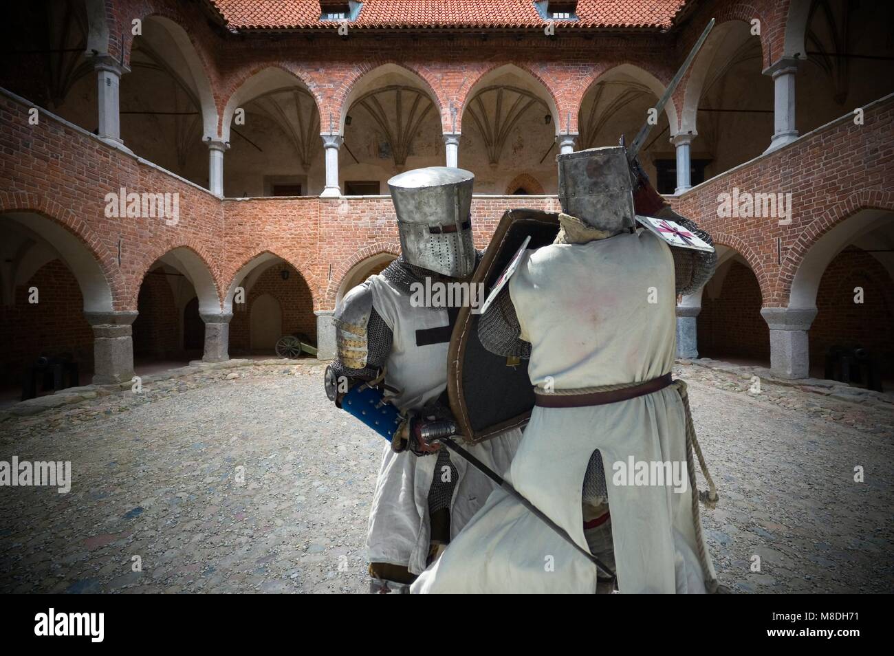 Armored fighting Teutonic knights on courtyard of Gothic medieval castle in Lidzbark Warminski, Poland Stock Photo