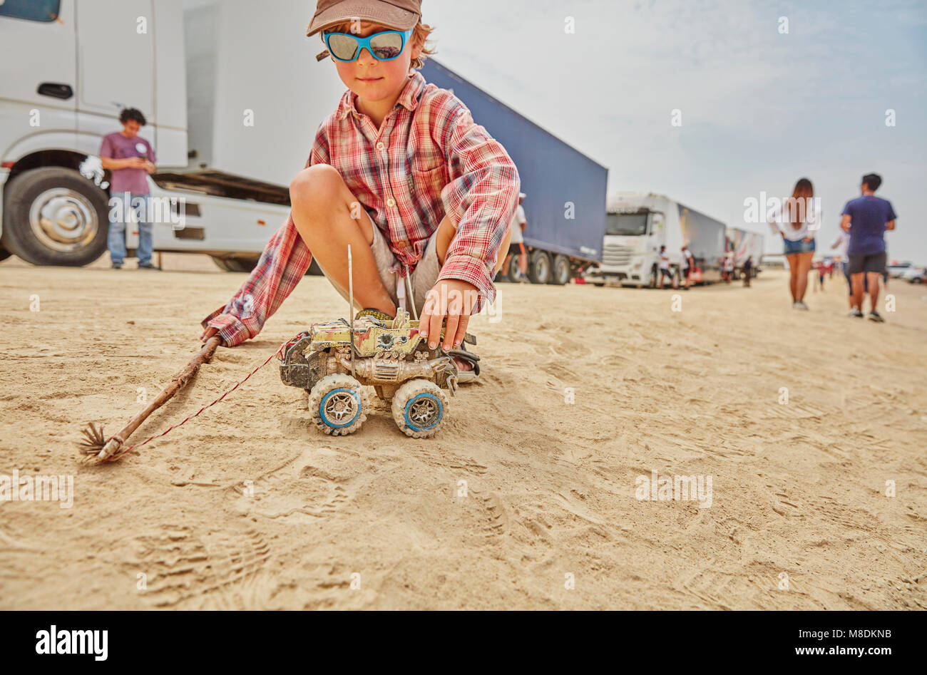 Boy playing with toy truck in sand, Ica, Peru Stock Photo