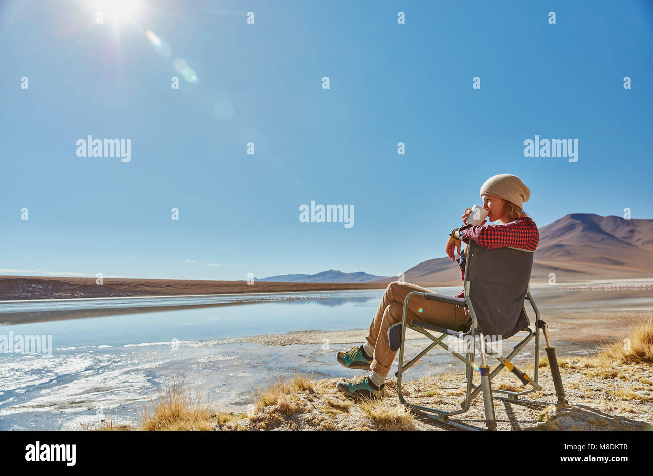 Woman sitting in camping chair, looking at view, Salar de Chalviri, Chalviri, Oruro, Bolivia, South America Stock Photo