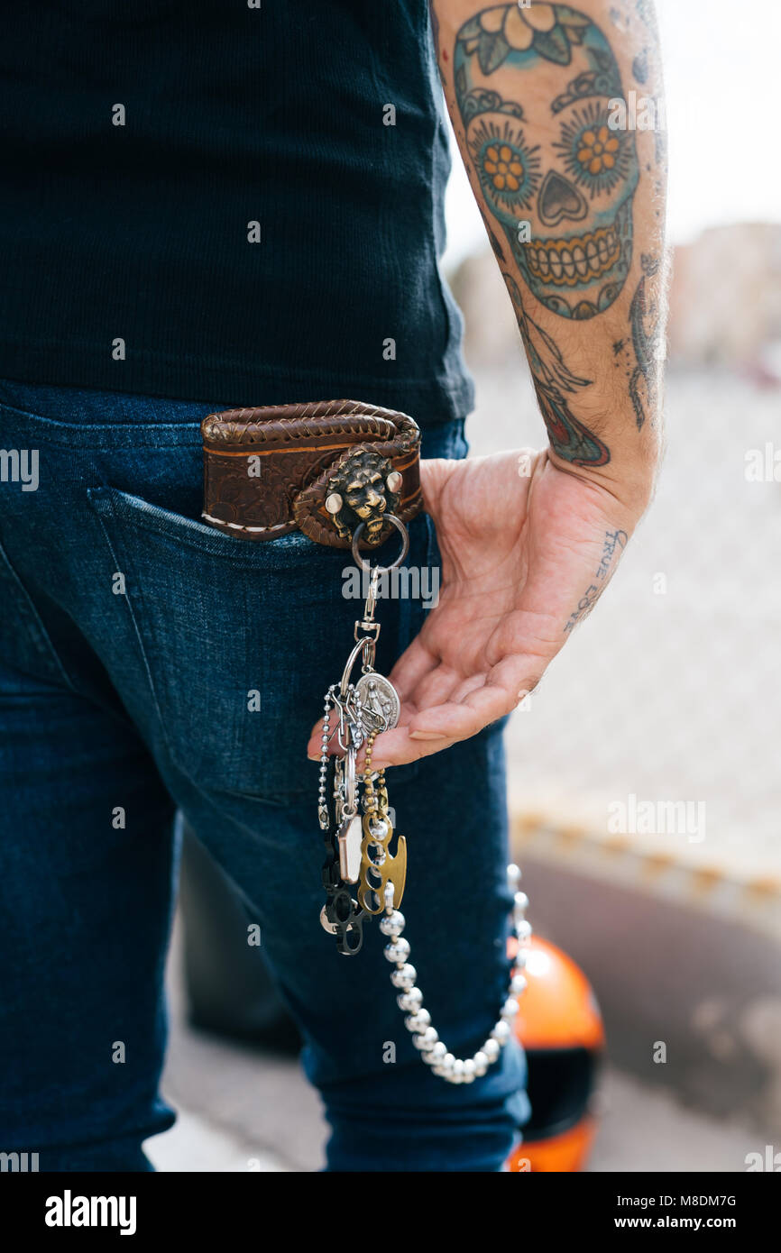 Rear view of man with keys in back pocket and skull tattoo, cropped Stock Photo