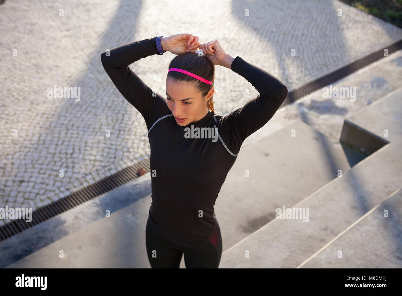 High angle view of young woman tying hair in ponytail Stock Photo