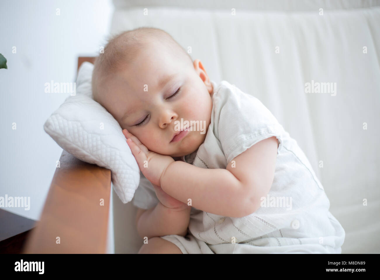 Little cute baby boy, sleeping in armchair with little pillow, cozy