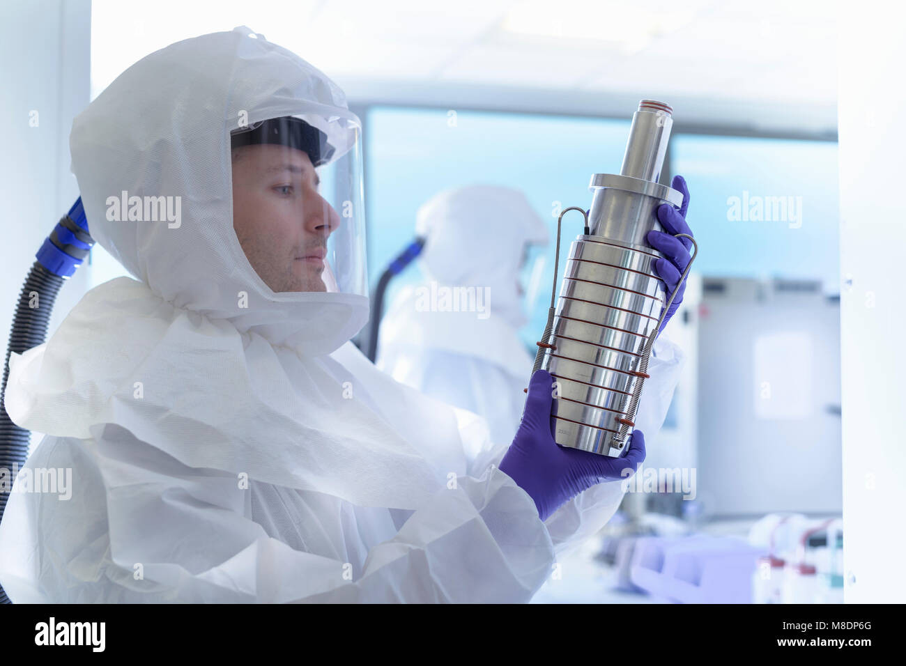 Scientist in protective wear inspecting filter in laboratory Stock Photo