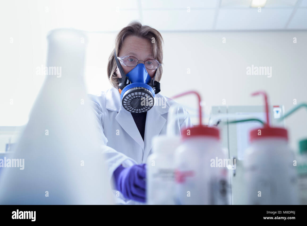 Scientist in breathing apparatus working in laboratory Stock Photo