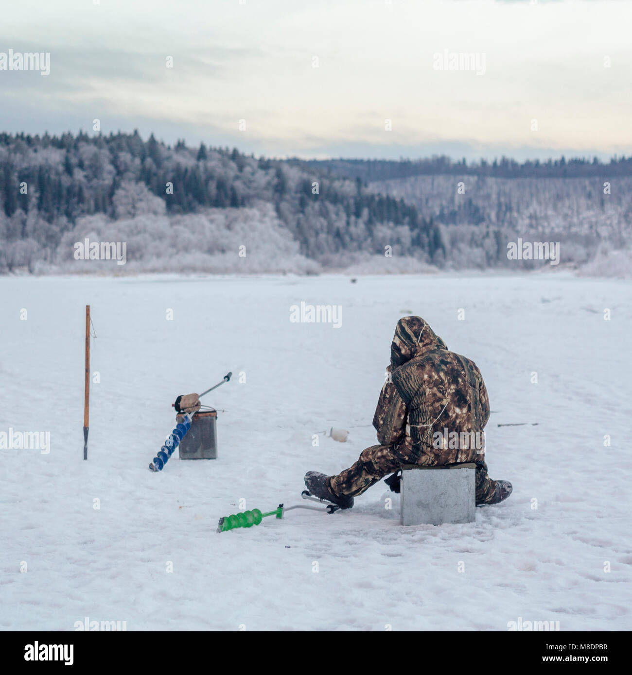 Man ice-fishing, Ural, Sverdlovsk, Russia Stock Photo