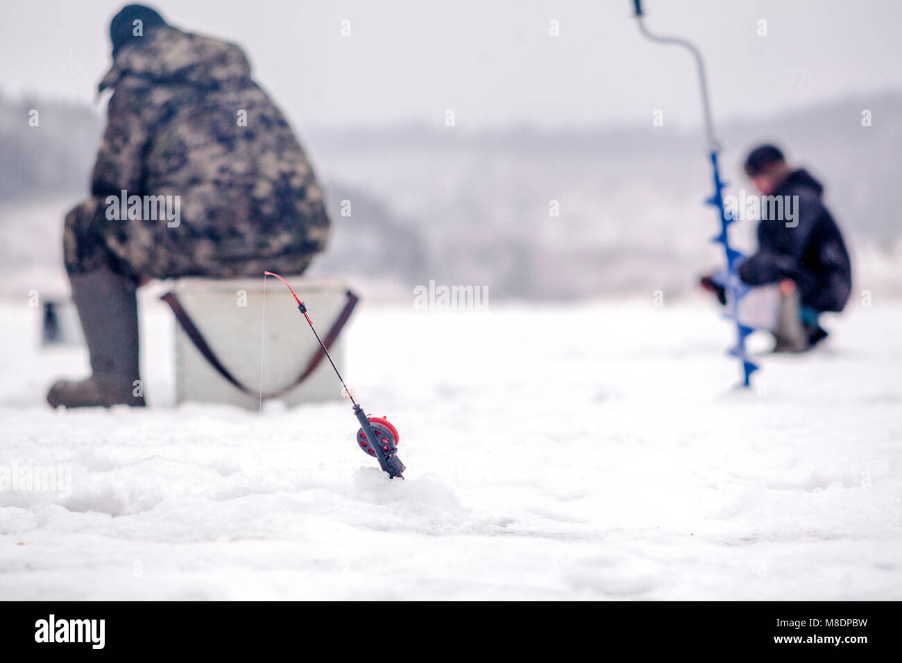 Men ice-fishing, Ural, Sverdlovsk, Russia Stock Photo