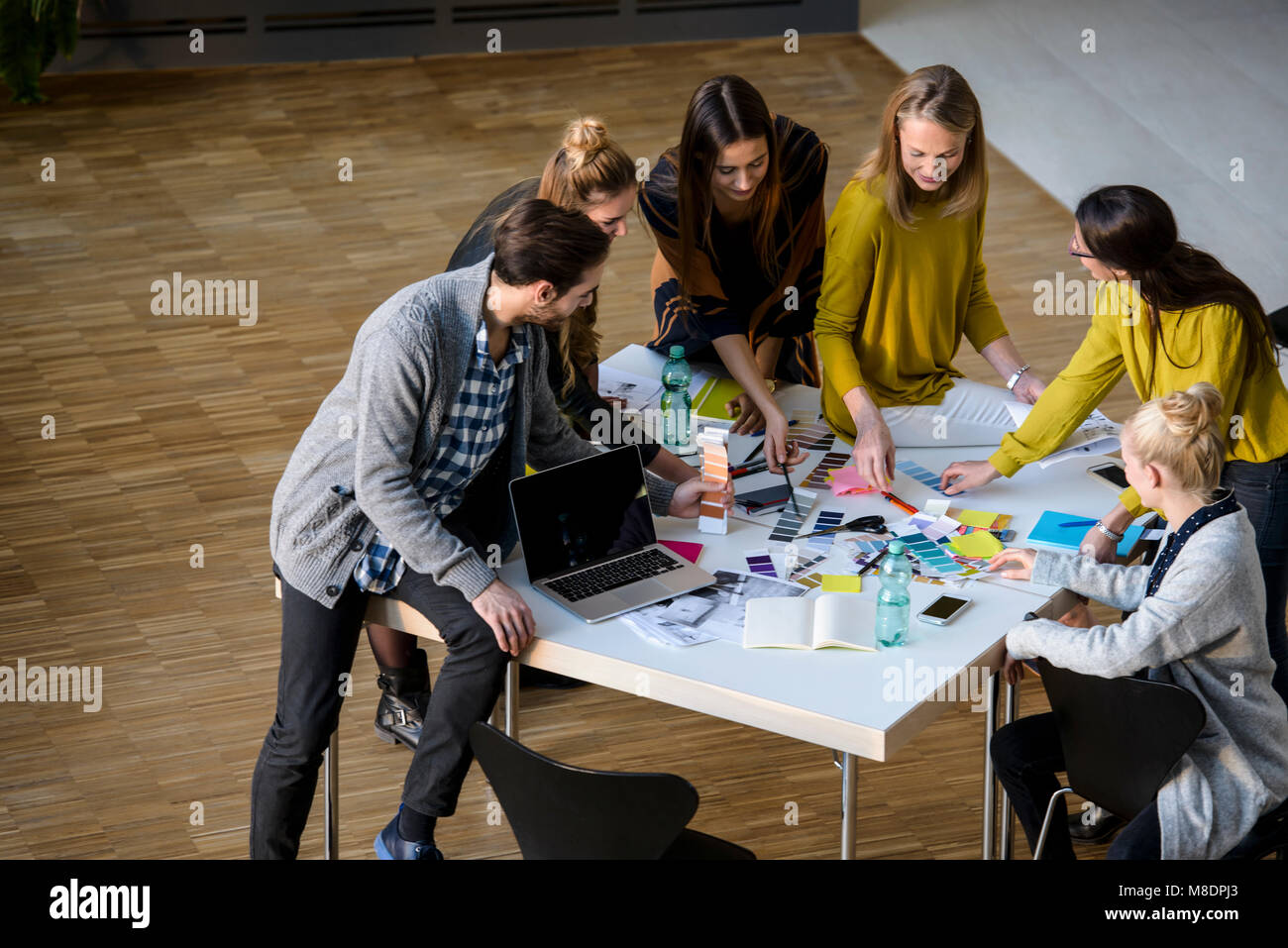Team of male and female designers discussing colour swatches on design ...