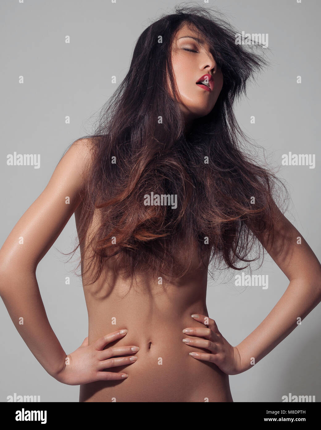 Portrait of nude young woman, long hair covering breasts, hands on hips  Stock Photo - Alamy