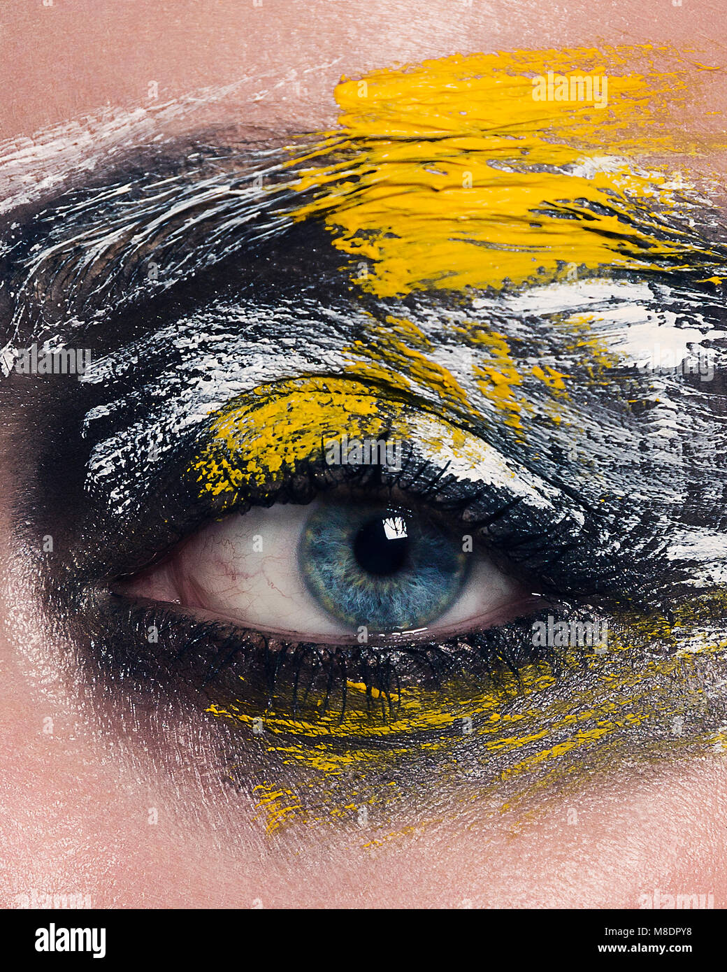 Studio portrait of blue eyed woman with painted face, close up of eye Stock Photo