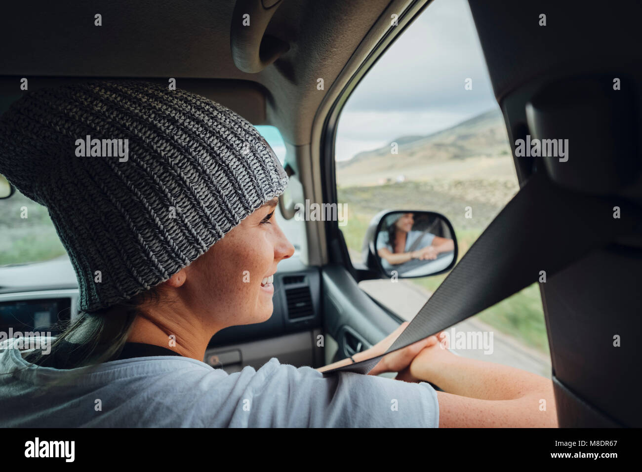 Young woman sitting in car, looking at view out of car window, Silverthorne, Colorado, USA Stock Photo