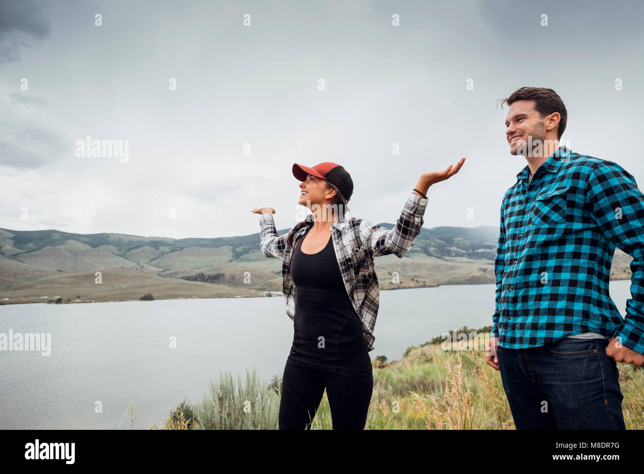 Couple walking near Dillon Reservoir, young woman's arms raised, Silverthorne, Colorado, USA Stock Photo