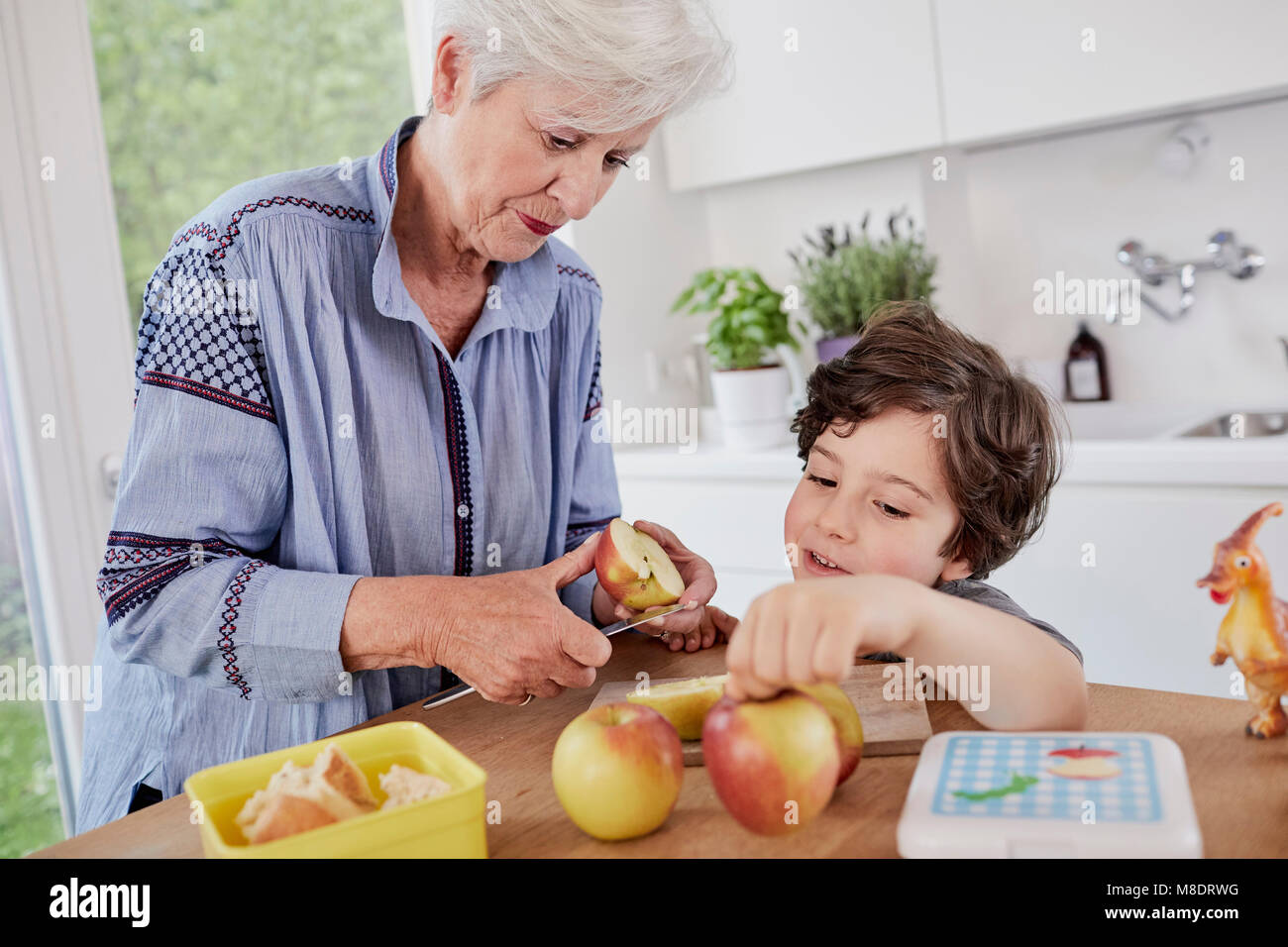 Grandmother and grandson preparing food in kitchen Stock Photo