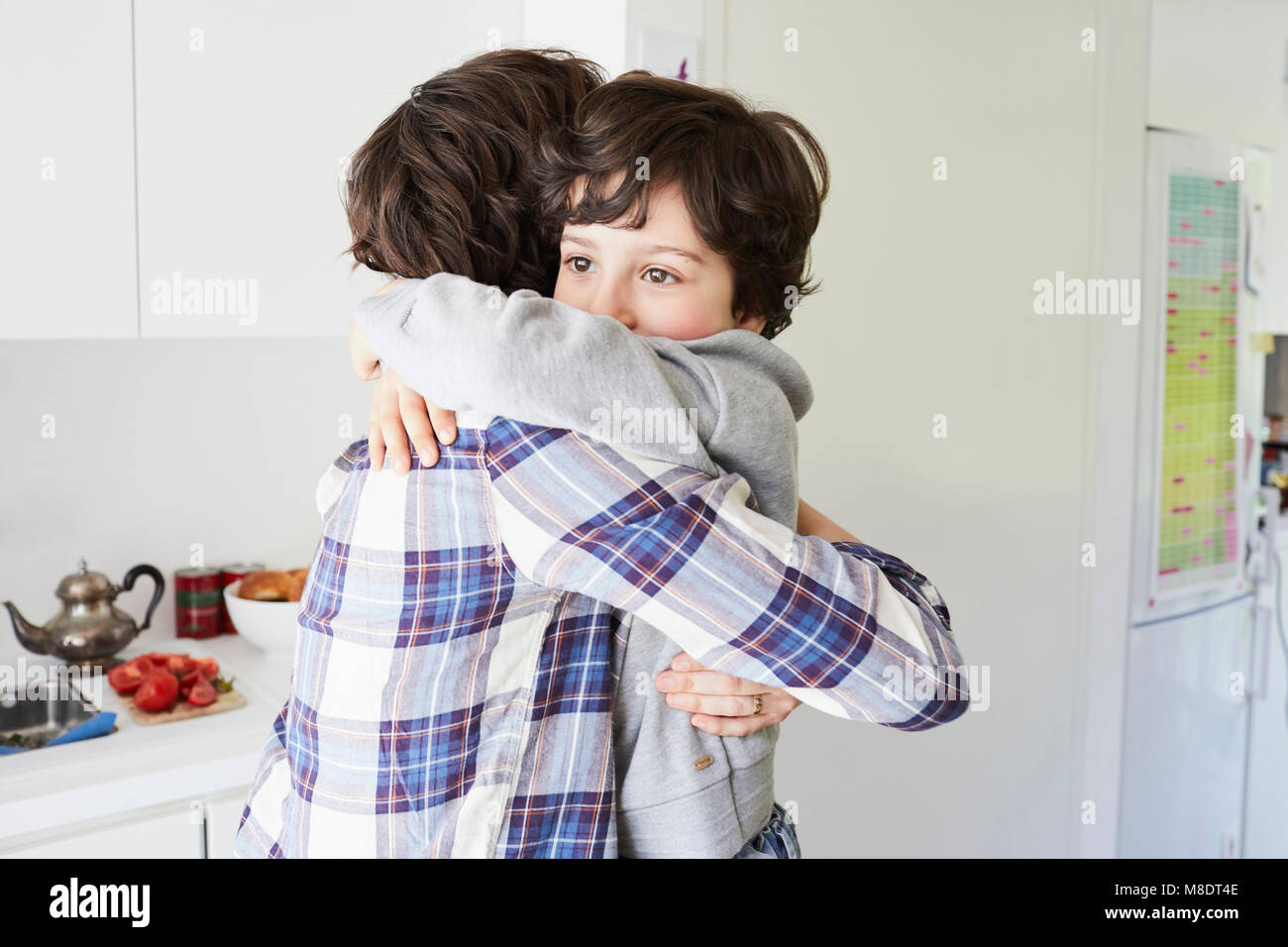 Mother and son at home, hugging Stock Photo