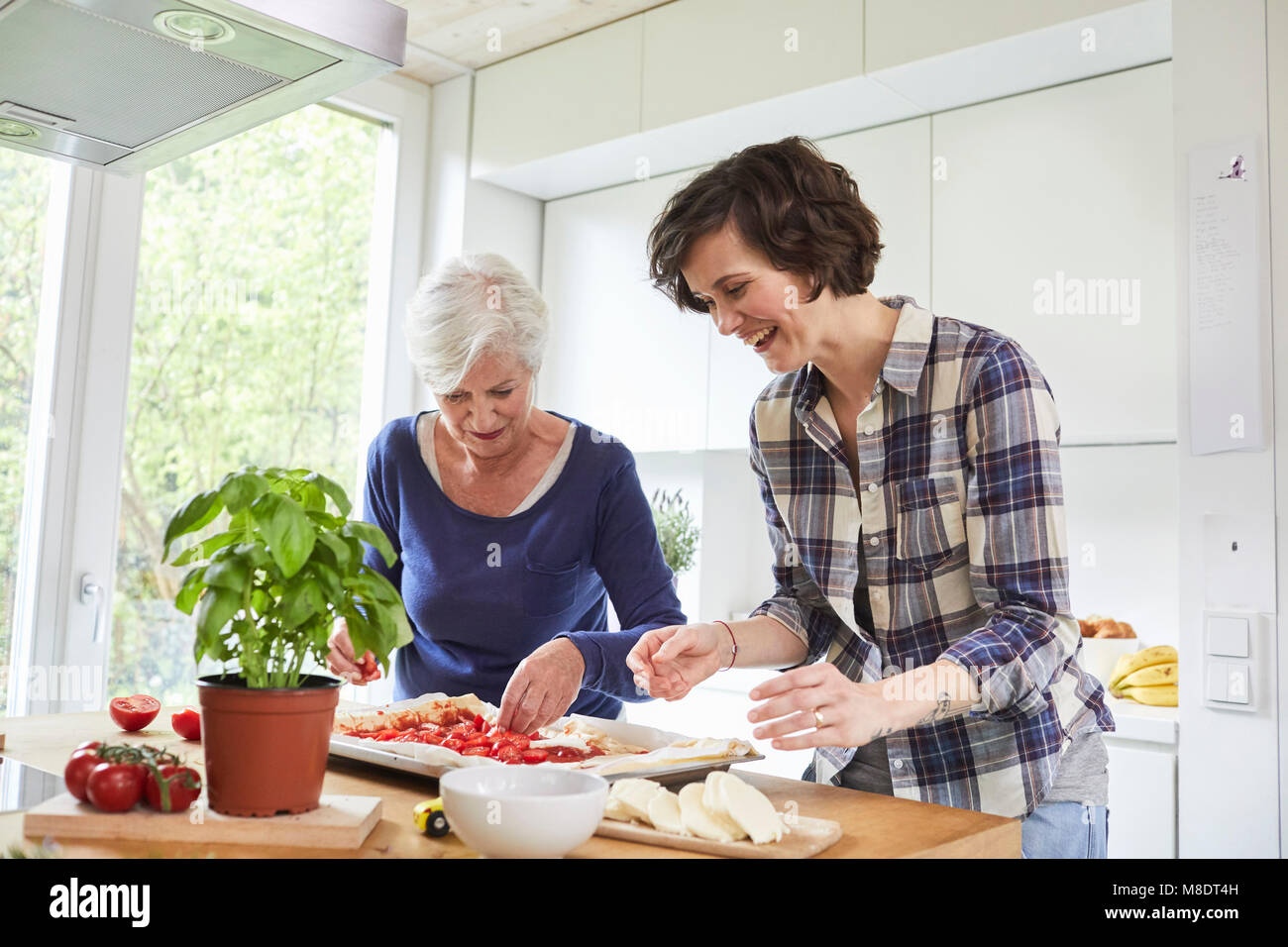 Mother and grown daughter at home, preparing food together Stock Photo