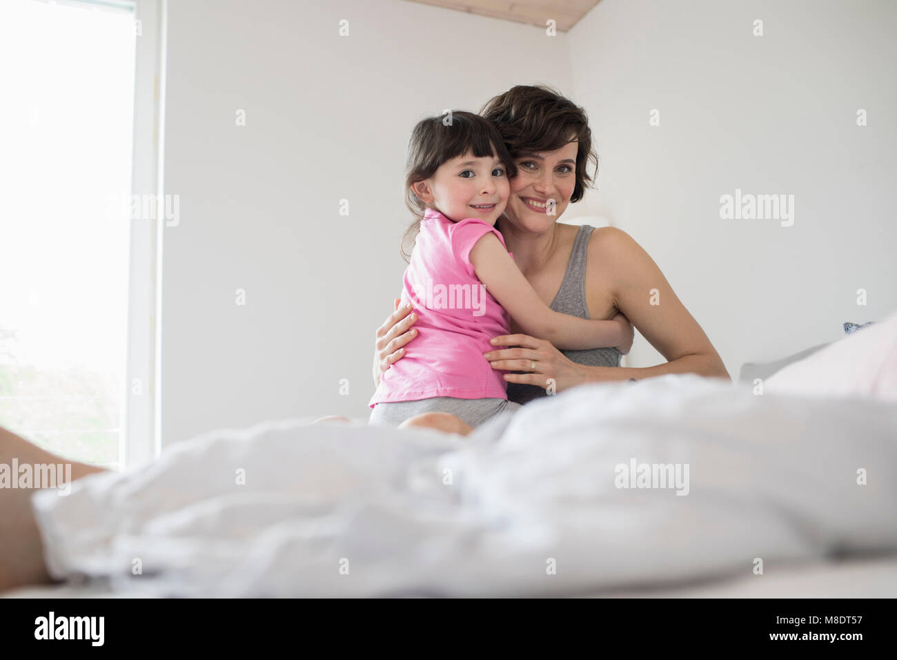 Portrait of mother and daughter at home, hugging Stock Photo