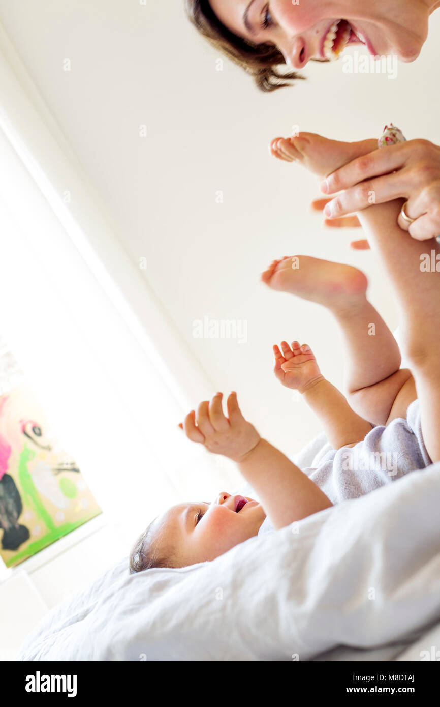 Mother playing with baby daughter, laughing Stock Photo