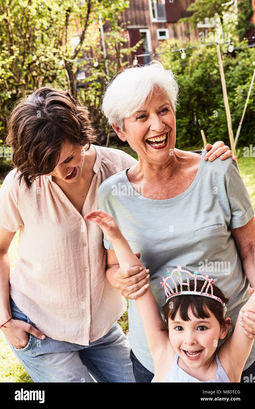 Portrait of senior woman with grown daughter and granddaughter, outdoors, laughing Stock Photo