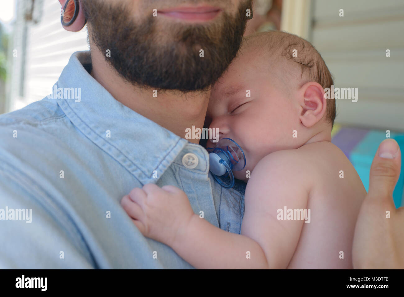 Man with sleeping baby boy on shoulder Stock Photo