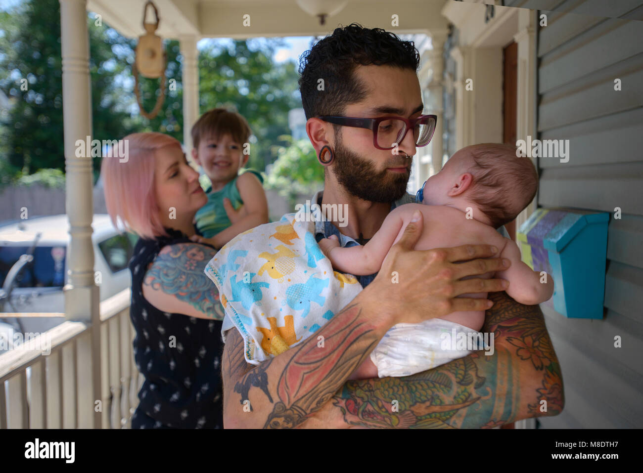 Family in front porch of house Stock Photo