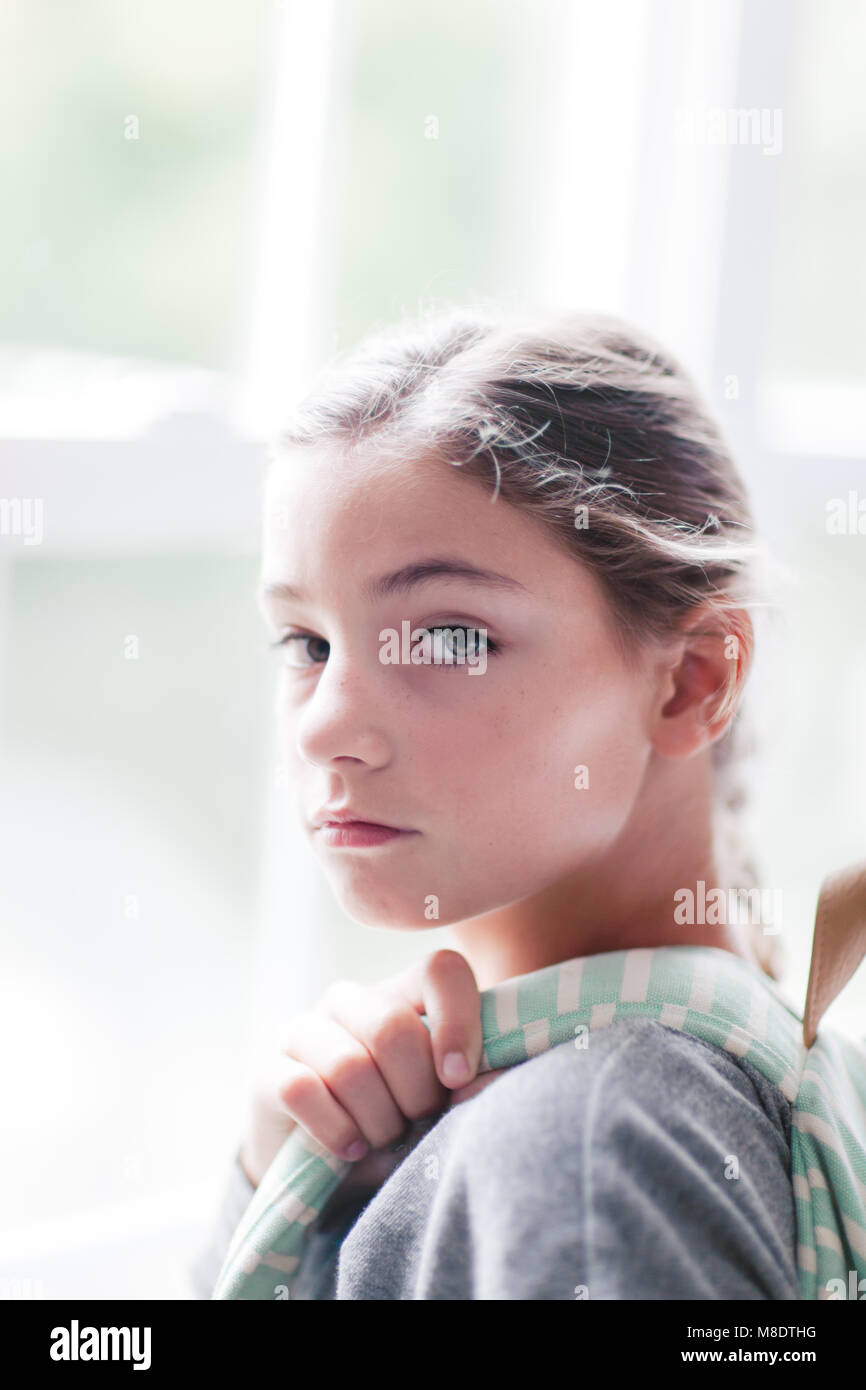 Girl with backpack looking over her shoulder Stock Photo