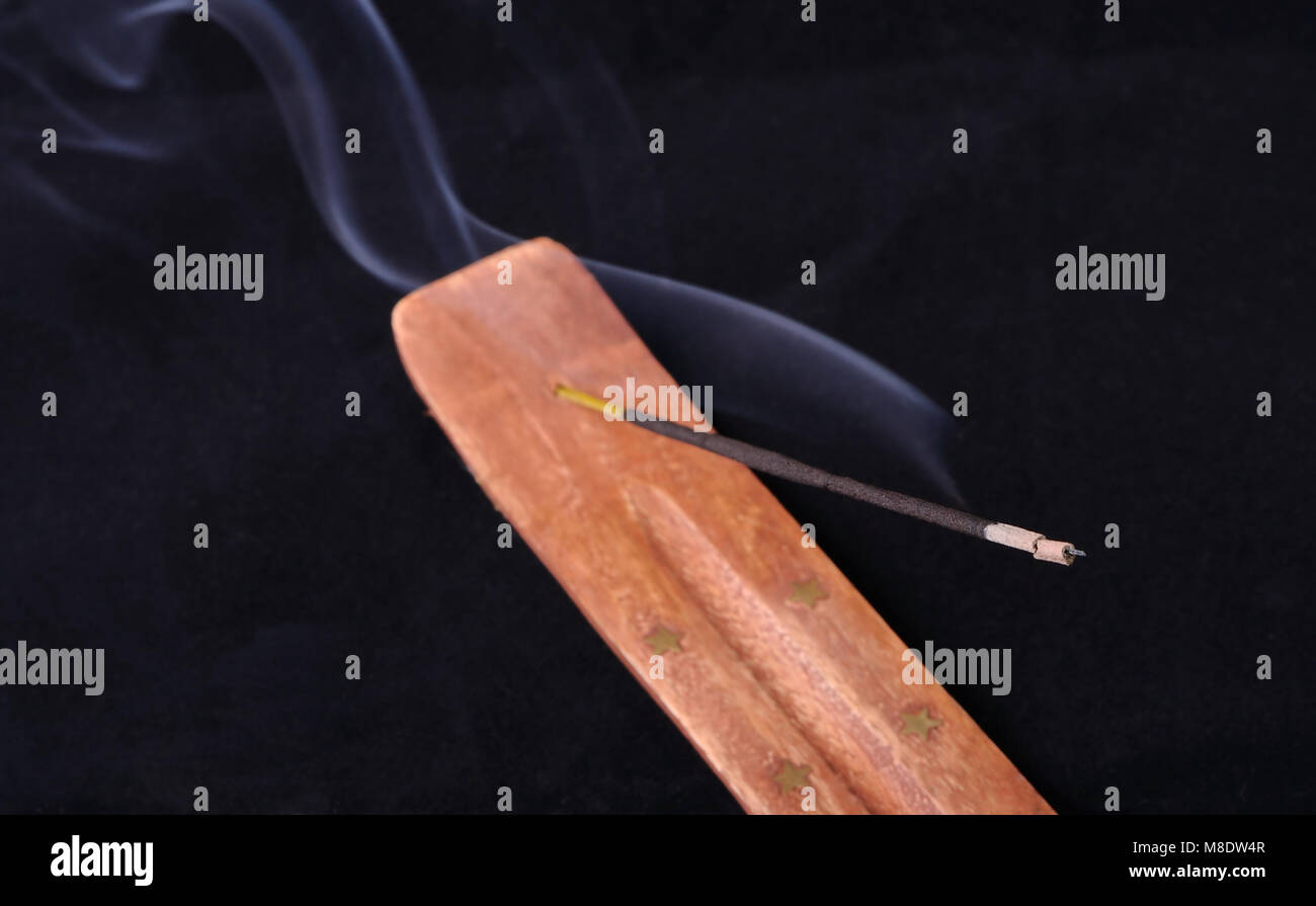 Smoldering incense stick on a stand Stock Photo