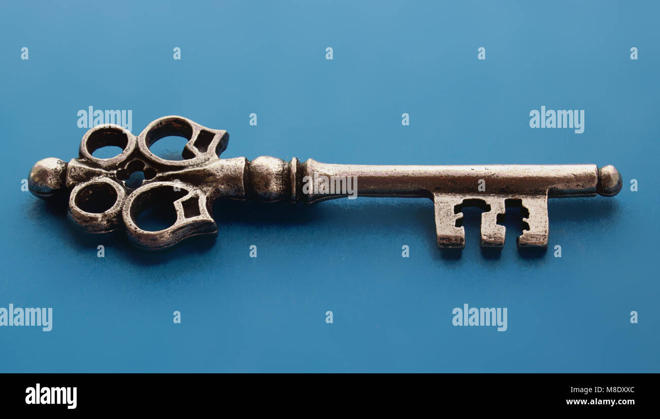 Isolated metal old key on the blue background Stock Photo - Alamy