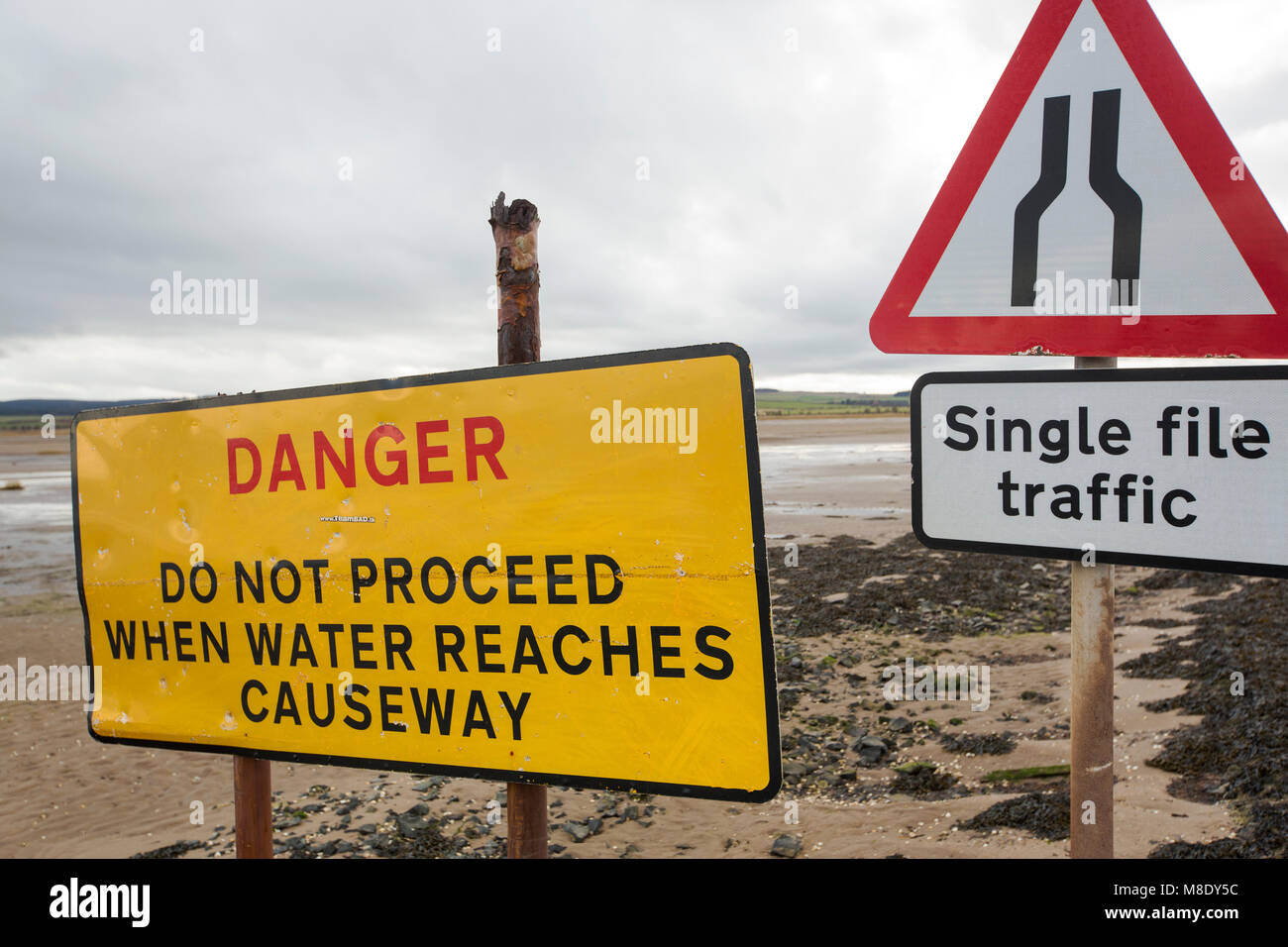 Warming signs about tidal flooding on the causeway to Holy Island, Northumberland, UK. Stock Photo