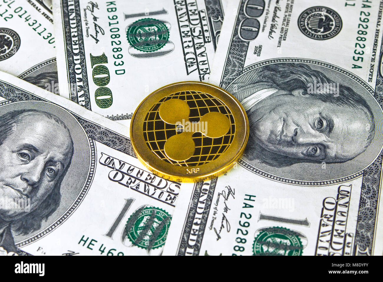 Ripple XRP Gold crypto on the one hundred dollar bills. Ripple XRP and  cryptocurrency investing concept. Blockchain and financial technology.  Transact Stock Photo - Alamy