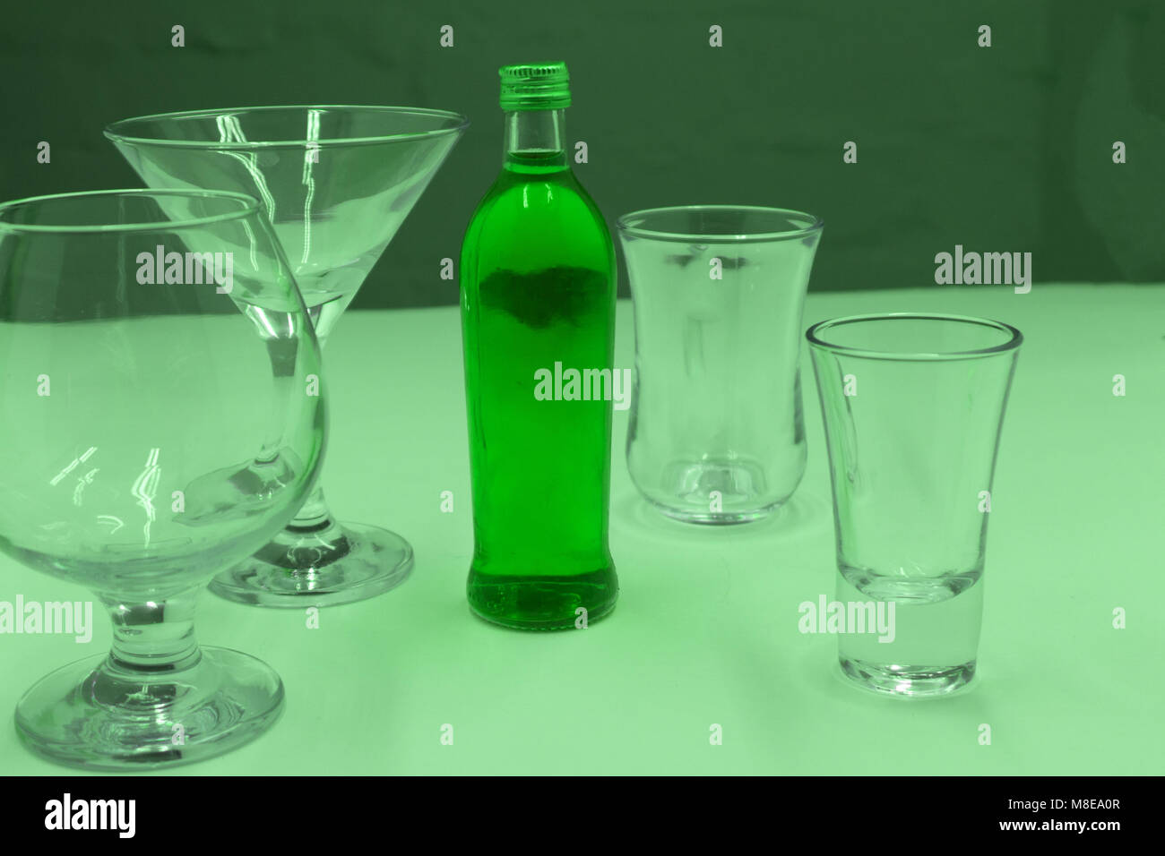 Absinthe, cold water standing in glass bottles on the table. Next a plate of caramel and glasses for drinks , Stock Photo