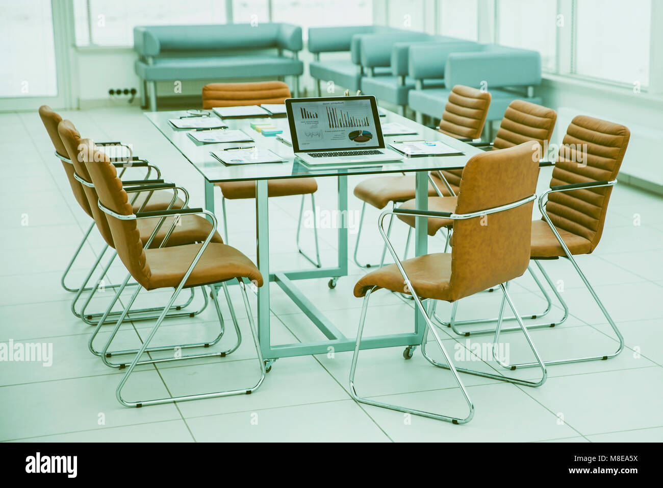 open laptop computer with financial charts and papers spread out on the ...