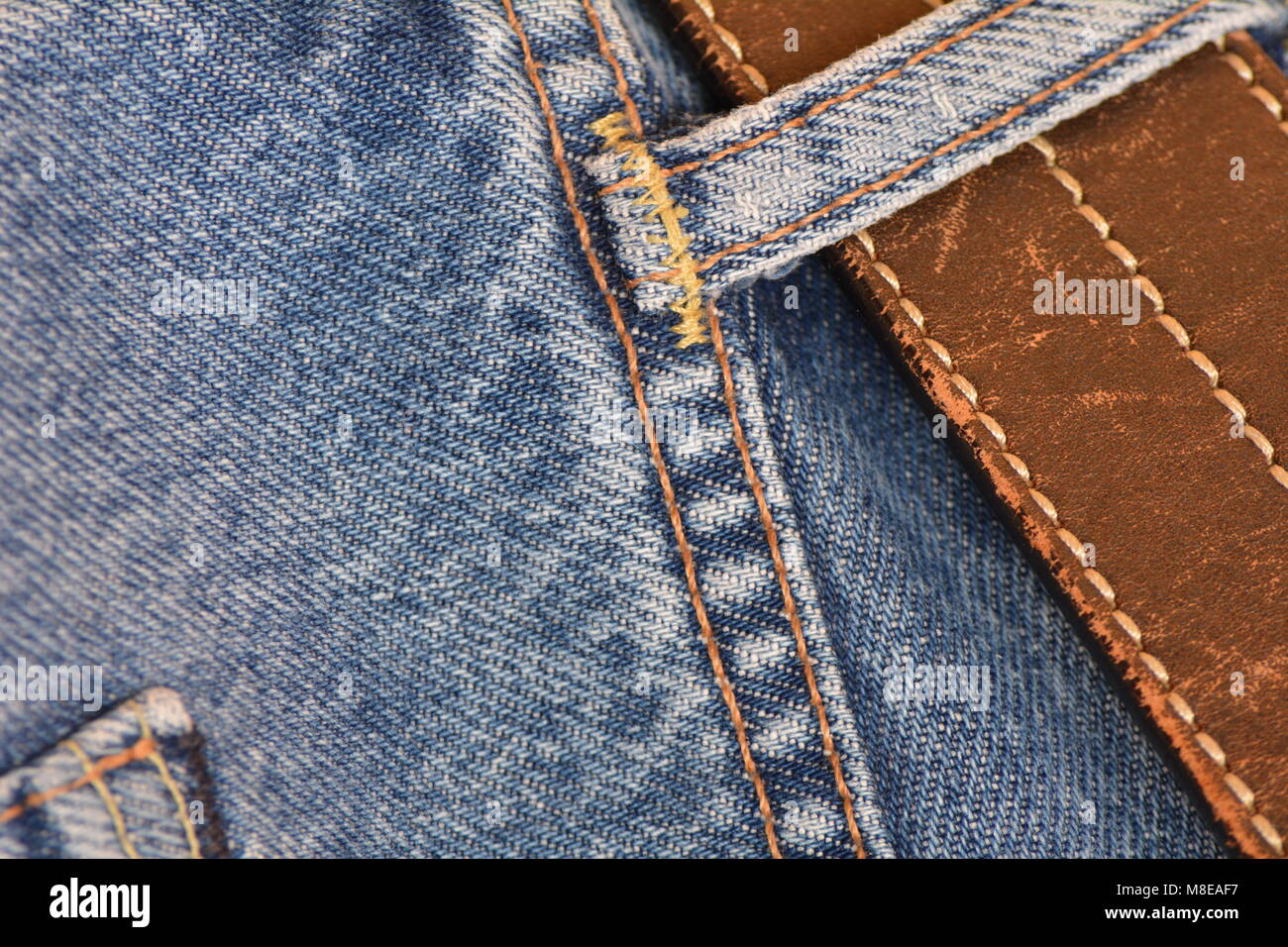 Pair of jeans with a battered leather belt, close-up Stock Photo