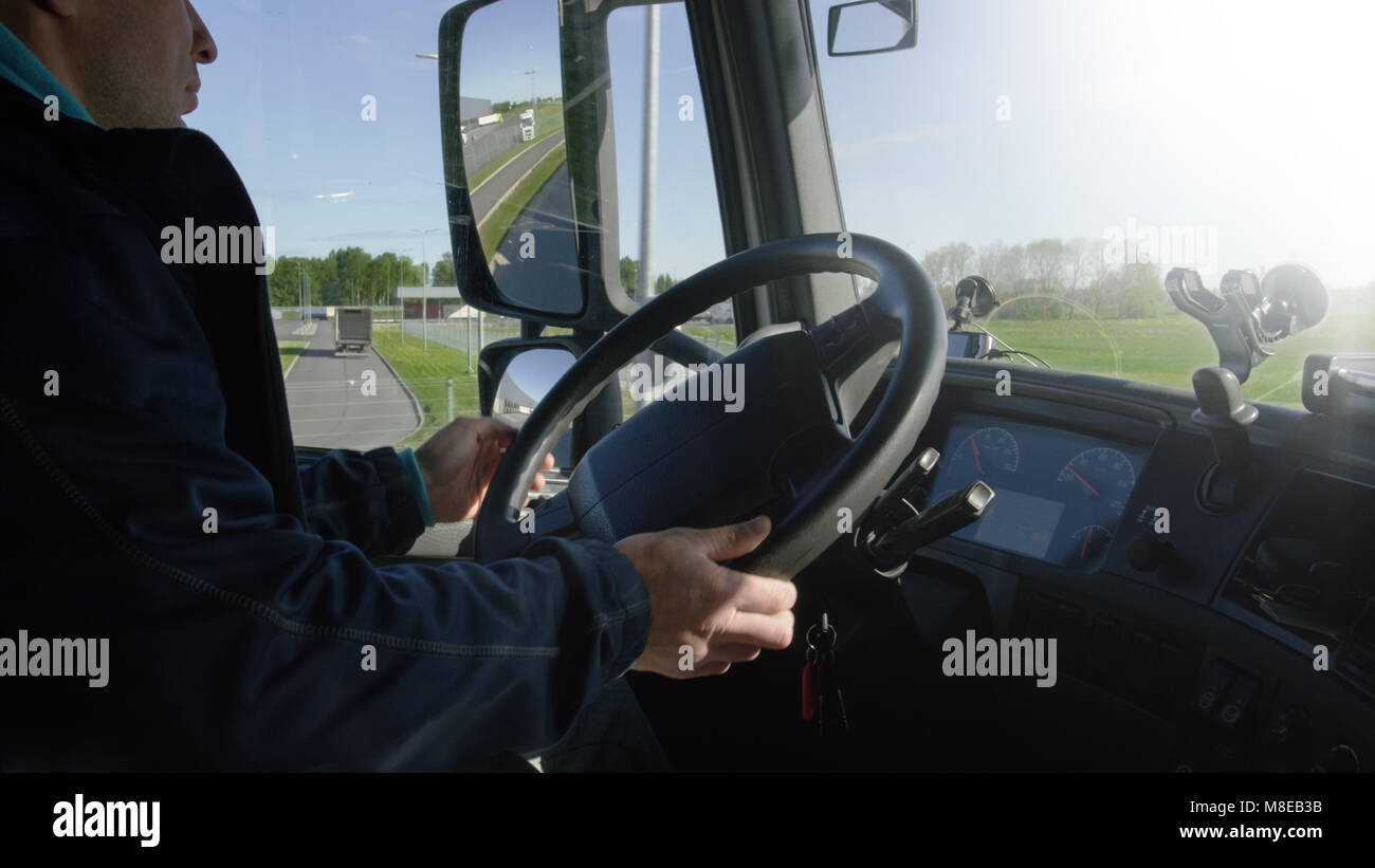 Inside of the Cabin View of the Professional Truck Driver Driving His Big  Vehicle on the Road. Stock Photo