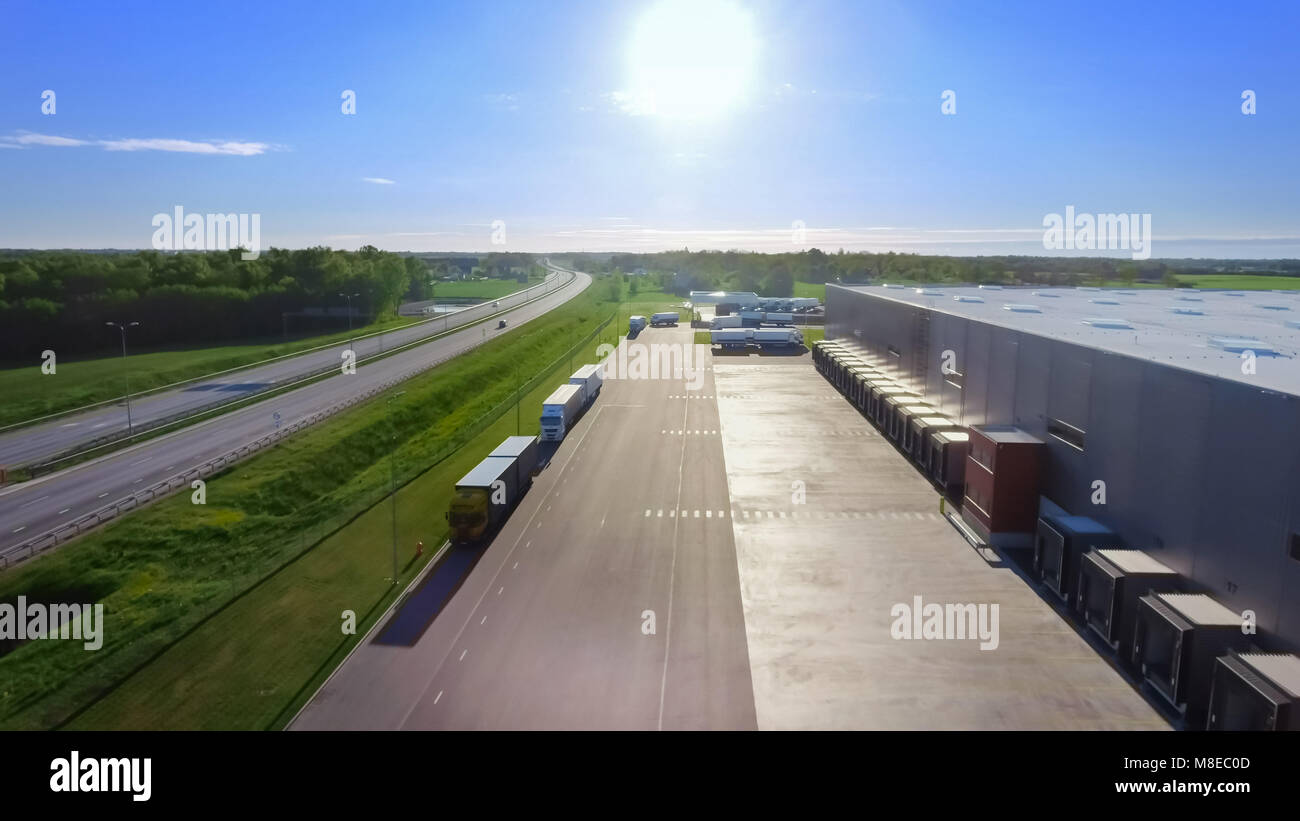 Aerial View of Loading Warehouse with Semi Trucks Parked and Waiting for Loading. Big Industrial Buildings, Supermarket Storage Facility. Stock Photo
