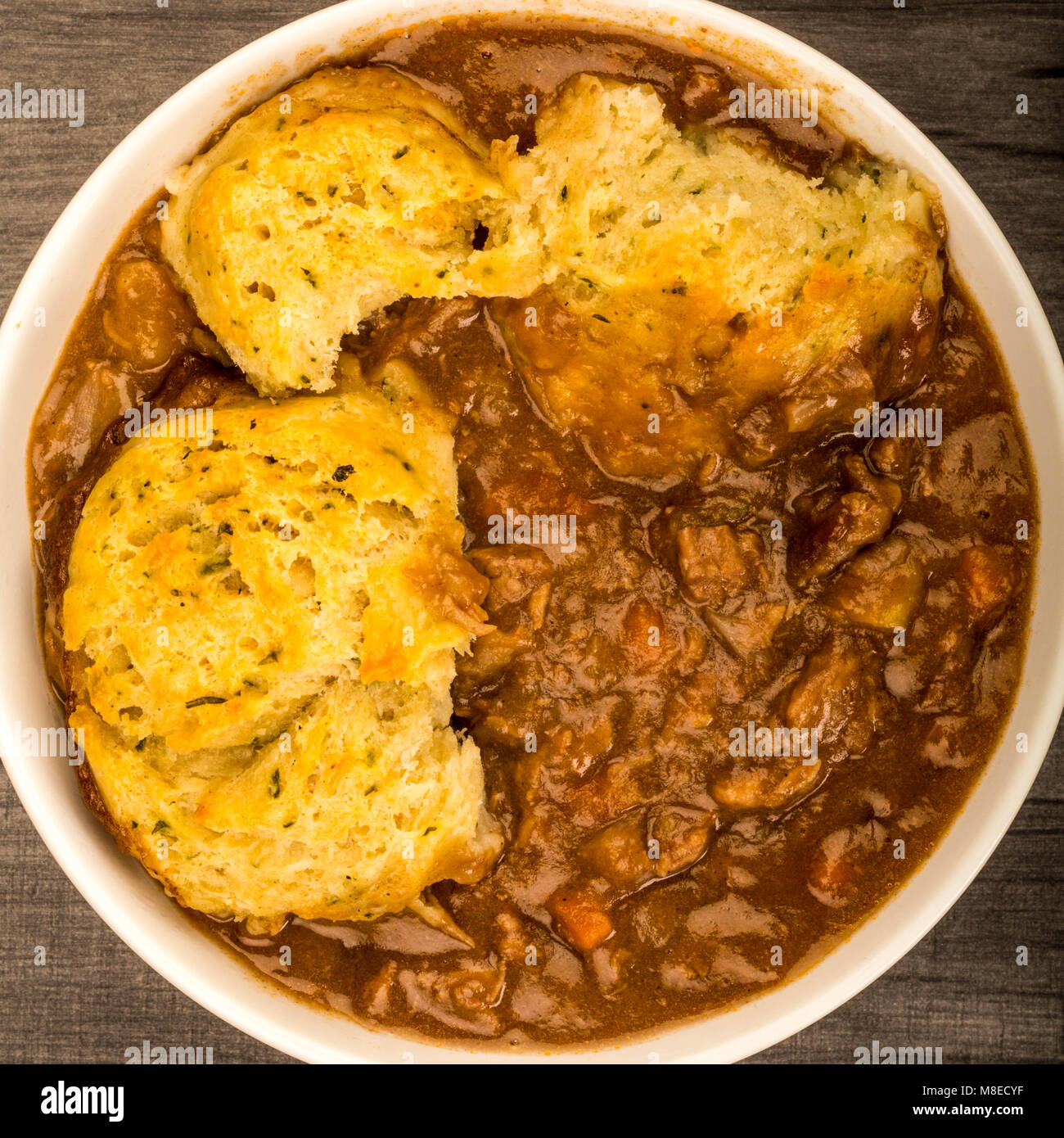 Traditional British Beef Casserole With Dumplings On A Dark Wooden Table Top Stock Photo