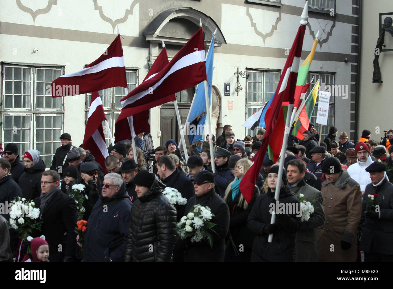 16 March 2018, Latvia, Riga: People marching with Latvian flags through the inner city during a commemoration march for Latvian Waffen-SS veterans in Riga. Latvian veterans of a unit of the Waffen-SS have commemorated their fallen comrades with the controversial march. On Friday about 1500 participants in the war and sympathisers marched through the capital of the Baltic EU and NATO country with massive police protection. Photo: Alexander Welscher/dpa Stock Photo