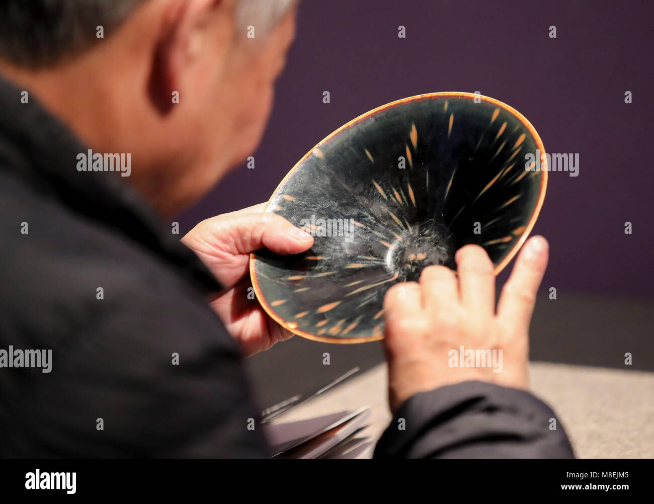 New York, USA. 16th Mar, 2018. A visitor looks at a Ding russet-splashed black-glazed conical bowl during the public viewing of Christie's Asian Art Week in New York, the United States, on March 16, 2018. Christie's on Friday kicked off its Asian Art Week, a series of auctions, viewings, and events, from March 16 to March 23. This season presents six distinct auctions including Fine Chinese Ceramics and Works of Art, South Asian Modern   Contemporary Art, etc. Credit: Wang Ying/Xinhua/Alamy Live News Stock Photo
