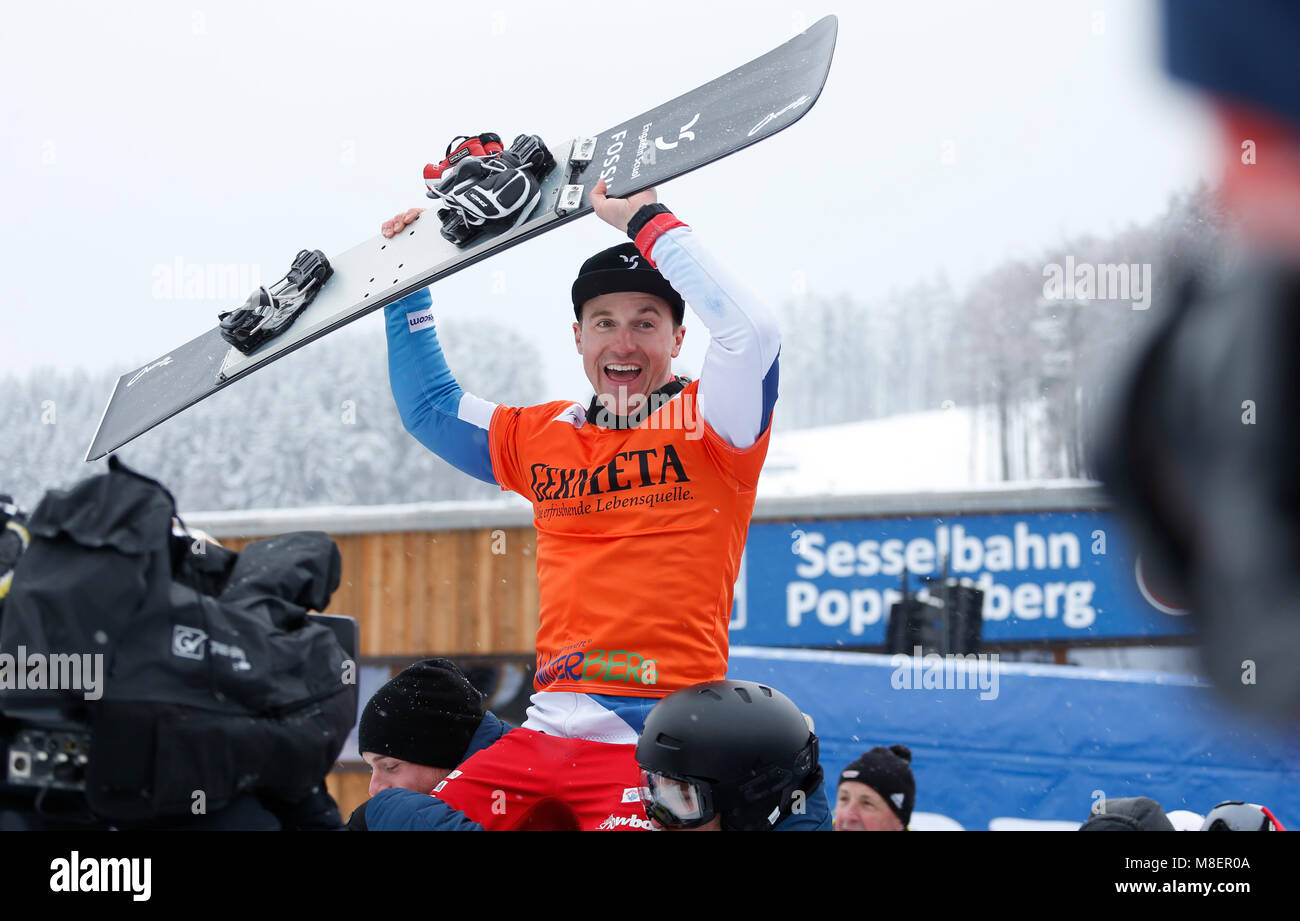 Winterberg, Germany, 17 March 2018, Snowboard World Cup, parallel slalom, men's single. Nevin Galmarini of Switzerland is carried to the victory ceremony for the overall world cup. Photo: Ina Fassbender/dpa Stock Photo